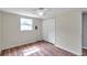 Bedroom featuring wood-look flooring, a window, and closet at 1740 Inman Nw Dr, Winter Haven, FL 33881