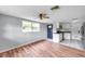 Bright living room with wood floors leading to a kitchen with stainless steel appliances at 1740 Inman Nw Dr, Winter Haven, FL 33881