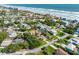 Aerial view of a residential neighborhood near a beach with the subject property indicated by a red arrow at 64 Alberta Ave, Ponce Inlet, FL 32127