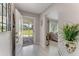 Inviting foyer with a clear view to the front lawn and peaking into the living room with neutral color palette at 64 Alberta Ave, Ponce Inlet, FL 32127