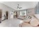 Open-concept living room with tile floors, a comfortable sofa, and lots of natural light from a large window at 64 Alberta Ave, Ponce Inlet, FL 32127