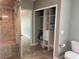 Bright bathroom featuring tiled shower with glass door and a built-in closet at 7144 Remington Oaks Loop, Lakeland, FL 33810