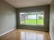 Bedroom featuring hardwood floor and large window with backyard views at 7144 Remington Oaks Loop, Lakeland, FL 33810