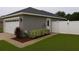 View of the rear of the home showcasing a privacy fence, two-car garage and well-maintained landscaping at 7144 Remington Oaks Loop, Lakeland, FL 33810