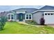 Charming single-story home featuring a stone accent entrance and a well-manicured front yard at 7144 Remington Oaks Loop, Lakeland, FL 33810