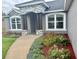 Close up of the home entrance featuring stone detail, an arched entryway, and beautiful landscaping at 7144 Remington Oaks Loop, Lakeland, FL 33810