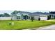 Well-maintained home featuring gray paint, an attached garage, and a lush green lawn at 7144 Remington Oaks Loop, Lakeland, FL 33810
