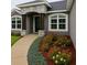Inviting home exterior with a curved walkway, colorful flowerbeds, and an arched entryway at 7144 Remington Oaks Loop, Lakeland, FL 33810