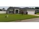 Attractive home with a well-manicured lawn, complemented by stone details and a two-car garage at 7144 Remington Oaks Loop, Lakeland, FL 33810