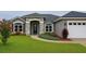 Charming single-story home featuring stone accents, a two-car garage, and beautifully landscaped front yard at 7144 Remington Oaks Loop, Lakeland, FL 33810