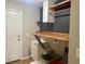 Practical laundry area with a sink, folding counter, open shelves, and convenient access to the backyard at 7144 Remington Oaks Loop, Lakeland, FL 33810