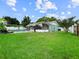 Spacious backyard featuring lush grass, a pool, and a screened in lanai at 1238 Honeytree E Ln, Lakeland, FL 33801