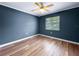 This bedroom has wood floors, blue-painted walls, white trim, and a window at 1238 Honeytree E Ln, Lakeland, FL 33801