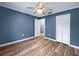 Spacious bedroom features wood floors, ceiling fan, closet, and blue-painted walls at 1238 Honeytree E Ln, Lakeland, FL 33801