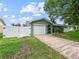 Charming single-story home showcasing a well-maintained yard, driveway, and a secure white fence at 1238 Honeytree E Ln, Lakeland, FL 33801