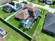 Aerial view of a fenced home featuring a screened-in pool, solar panels and a green lawn at 449 Moscato Dr, Davenport, FL 33897