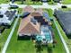 Aerial view of a fenced home featuring a screened-in pool, solar panels and well-maintained lawn at 449 Moscato Dr, Davenport, FL 33897
