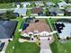 Aerial view of a home with a screened-in pool, solar panels, and a well-maintained yard at 449 Moscato Dr, Davenport, FL 33897