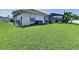 Backyard with green grass, screened-in patio, grill and storage bin at 449 Moscato Dr, Davenport, FL 33897