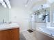 Bathroom featuring wood vanity, marble countertop, shower, and a garden tub with hanging plants at 449 Moscato Dr, Davenport, FL 33897