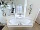 Bright bathroom with a soaking tub, shower, decorative plants and a window bringing in natural light at 449 Moscato Dr, Davenport, FL 33897