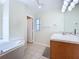 Bright bathroom features wood vanity, marble countertop, garden tub, and a doorway at 449 Moscato Dr, Davenport, FL 33897