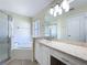 Bright bathroom featuring double sink vanity, soaking tub and glass-enclosed shower with white tile surround at 449 Moscato Dr, Davenport, FL 33897