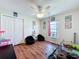 Bedroom with wood floors, ceiling fan, closet, a window, and a play area at 449 Moscato Dr, Davenport, FL 33897