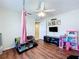 Bedroom showcasing wood floors, ceiling fan, a play area and a pet cage at 449 Moscato Dr, Davenport, FL 33897