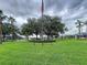 Community space featuring a grassy area, trees and an American flag on a pole at 449 Moscato Dr, Davenport, FL 33897