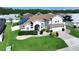 Two-story home with a well-manicured lawn, landscaping, and solar panels on the roof at 449 Moscato Dr, Davenport, FL 33897