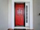 Bright red front door offers curb appeal to the home's exterior at 449 Moscato Dr, Davenport, FL 33897