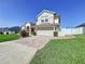Charming two-story home with a well-manicured lawn and a brick driveway at 449 Moscato Dr, Davenport, FL 33897