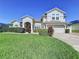 Beautiful two-story home with a well-manicured lawn and a charming red front door at 449 Moscato Dr, Davenport, FL 33897