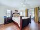 Relaxing main bedroom with a four-poster bed, wood floors, and access to the pool area at 449 Moscato Dr, Davenport, FL 33897