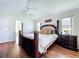 Comfortable main bedroom with vaulted ceilings, wood floors, and access to the en-suite bathroom at 449 Moscato Dr, Davenport, FL 33897
