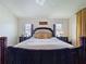 Well-lit main bedroom with wood floors, a four poster bed, and stylish nightstands at 449 Moscato Dr, Davenport, FL 33897