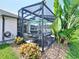 Screened lanai offers shaded seating area and view of lush tropical foliage at 449 Moscato Dr, Davenport, FL 33897
