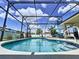 Private, screened-in pool area with blue skies, clear pool, and patio seating at 449 Moscato Dr, Davenport, FL 33897