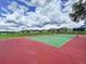 Outdoor tennis court with green and red surfaces surrounded by a chain-link fence at 449 Moscato Dr, Davenport, FL 33897