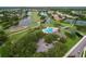 Aerial view of a community with a pool, golf course, tennis courts and lush green landscaping at 776 Grasslands Village Cir # 776, Lakeland, FL 33803