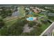 Aerial view of a community with a pool, golf course, tennis courts and lush green landscaping at 776 Grasslands Village Cir # 776, Lakeland, FL 33803
