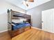 Bedroom with a wooden bunk bed and hardwood floors, ceiling fan, and gray accent wall at 776 Grasslands Village Cir # 776, Lakeland, FL 33803
