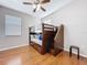 Bedroom with hardwood floors, a ceiling fan, and a wooden bunk bed with storage drawers at 776 Grasslands Village Cir # 776, Lakeland, FL 33803