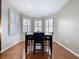 Sunlit dining area with hardwood floors, plantation shutters, and a modern dining table at 776 Grasslands Village Cir # 776, Lakeland, FL 33803