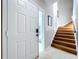 Inviting entryway featuring an open door, staircase, tiled floors, and plenty of natural light at 776 Grasslands Village Cir # 776, Lakeland, FL 33803