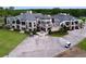 Elegant clubhouse featuring covered patios, lush landscaping, and golf carts on the driveway at 776 Grasslands Village Cir # 776, Lakeland, FL 33803