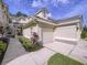 Lovely townhome featuring a beige exterior, lush landscaping, and an attached one car garage offering convenient parking at 776 Grasslands Village Cir # 776, Lakeland, FL 33803
