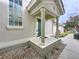 Inviting front porch featuring stately white pillars, rock landscaping, and a vibrant green door at 776 Grasslands Village Cir # 776, Lakeland, FL 33803
