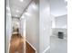 Well-lit hallway with hardwood flooring leading to the laundry room at 776 Grasslands Village Cir # 776, Lakeland, FL 33803